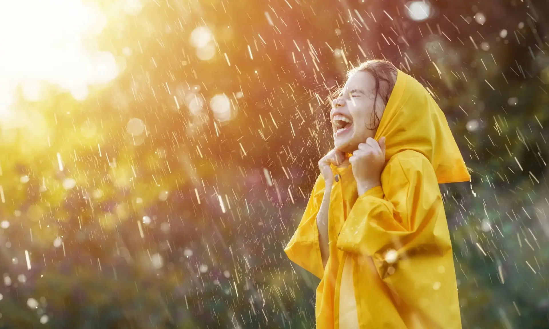 Bambina sorridente sotto la pioggia