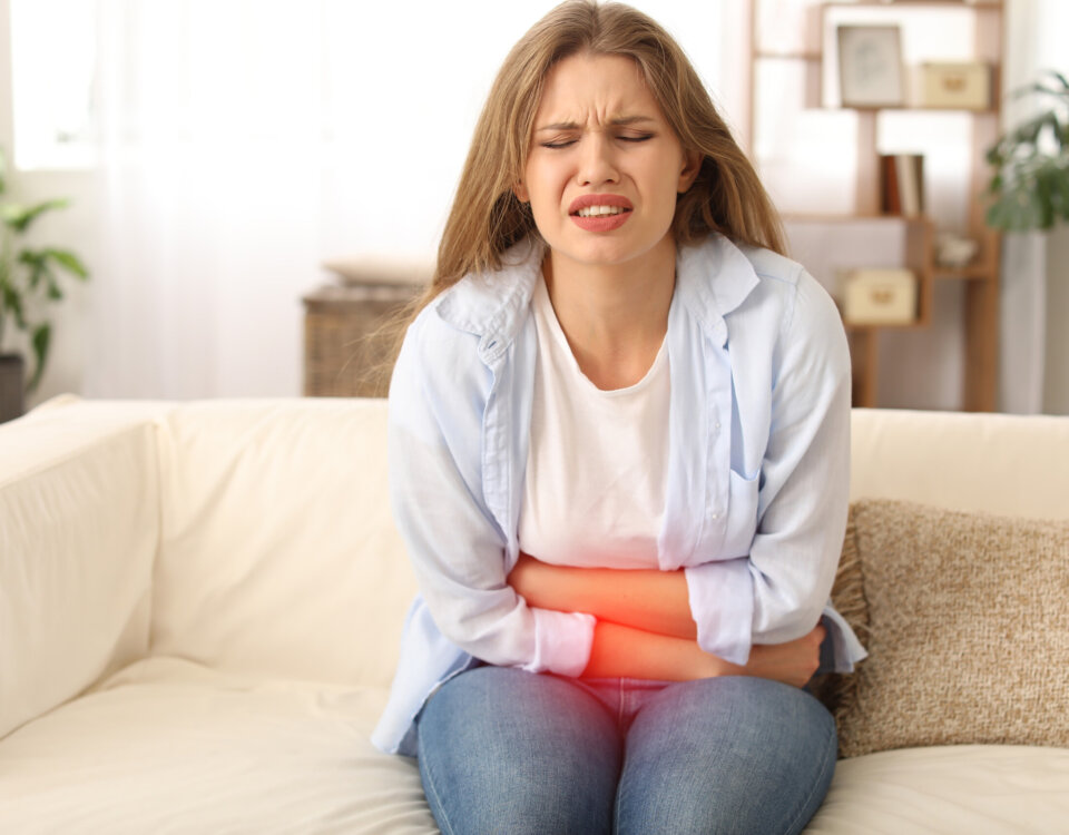 Young woman suffering from menstrual cramps at home