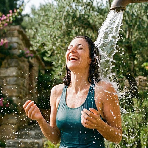 Donna sorridente sotto la doccia