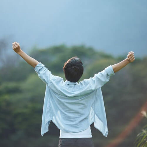 Persona che celebra la natura stendendo le braccia